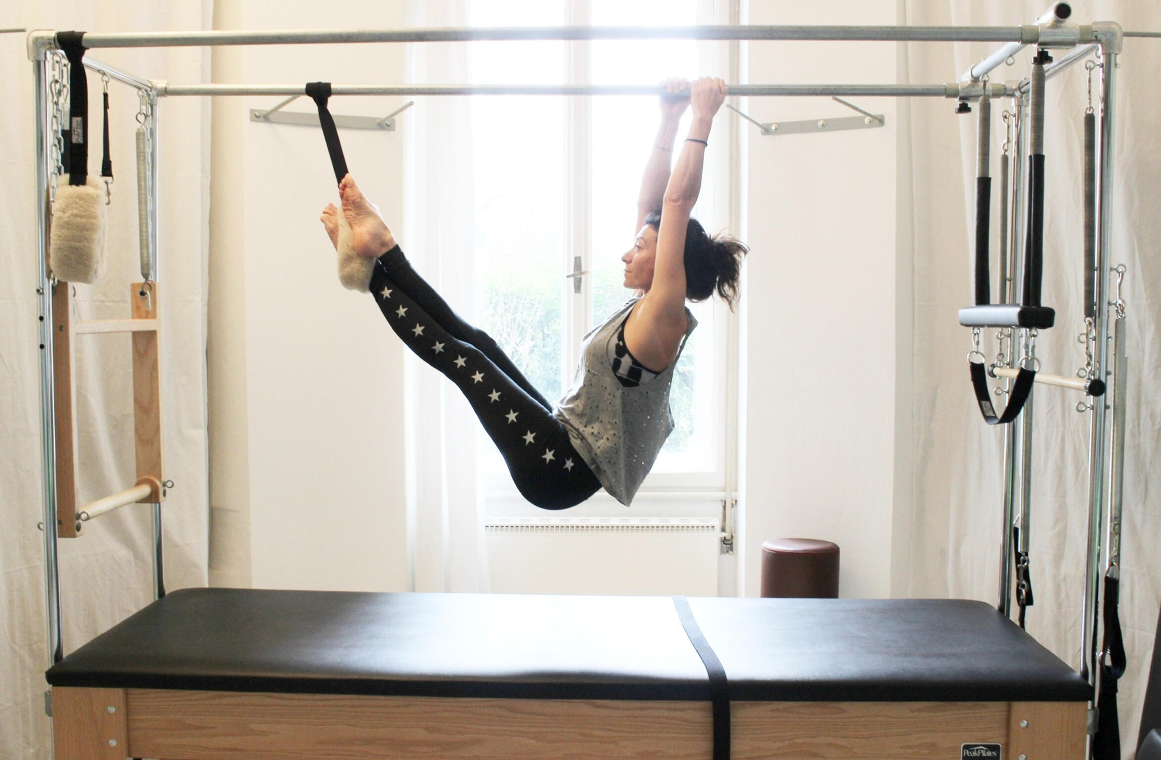 insegnante-qualificata-pilates-bolzano insegnante di pilates mentre svolge esercizio su macchina professionale Cadillac